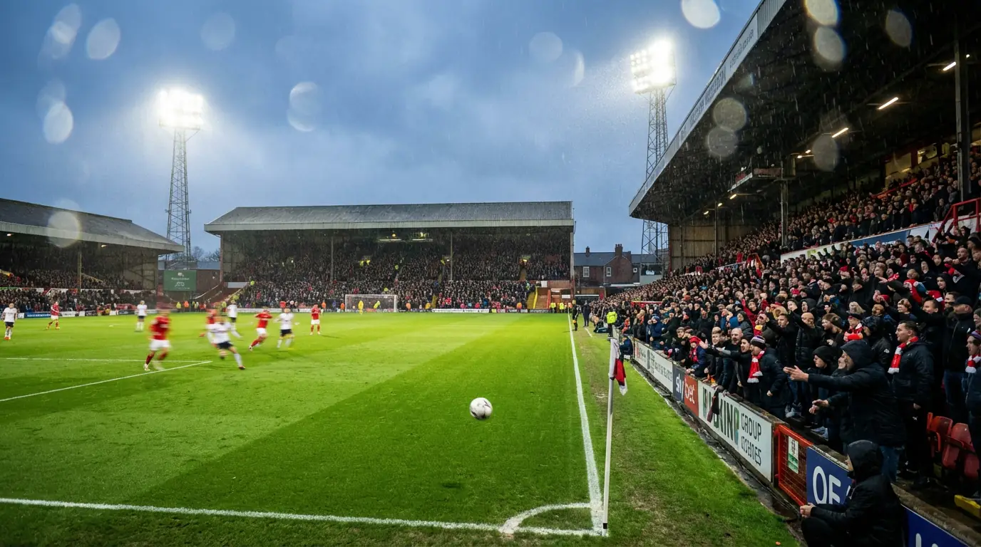 Estadio de la Premier League lleno de aficionados durante un partido nocturno de fútbol
